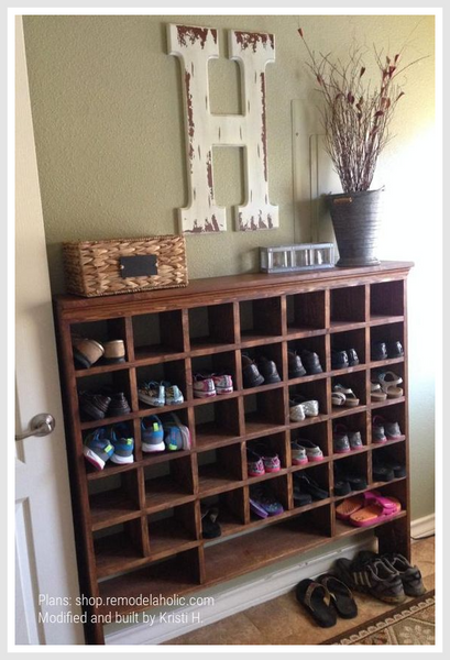 Foyer with a wooden shoe rack, holding multiple pairs of shoes.