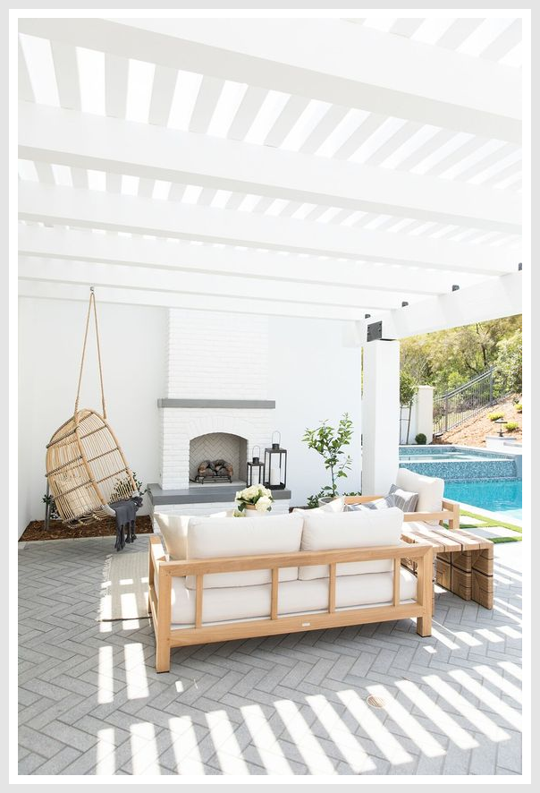 Rattan hanging chair and furniture on a patio, under a white roof