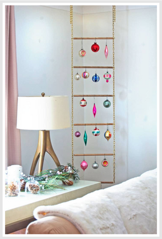 Christmas ornaments hanged on a piece of decor that looks like ladder