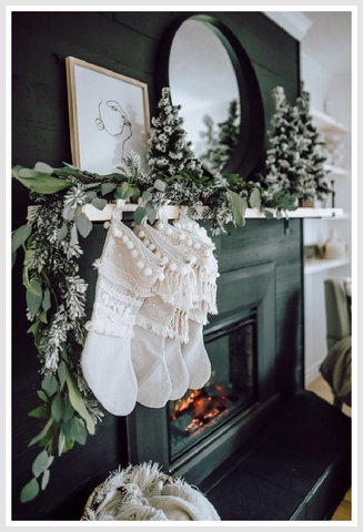 White Christmas stockings suspended above the dark green fireplace.