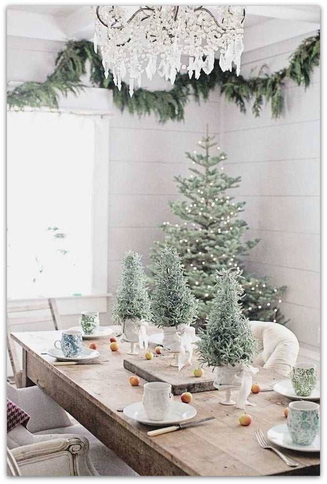 Winter-themed living room corner in a white color palette, with a Christmas tree and festive table decorations.