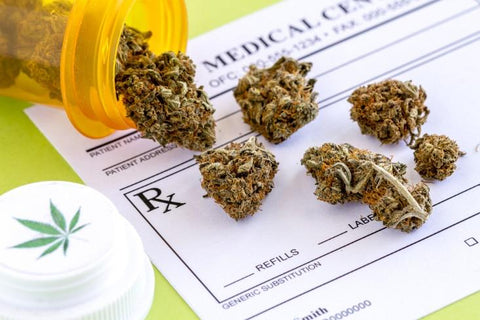 Medical marijuana buds spilling out of a prescription bottle