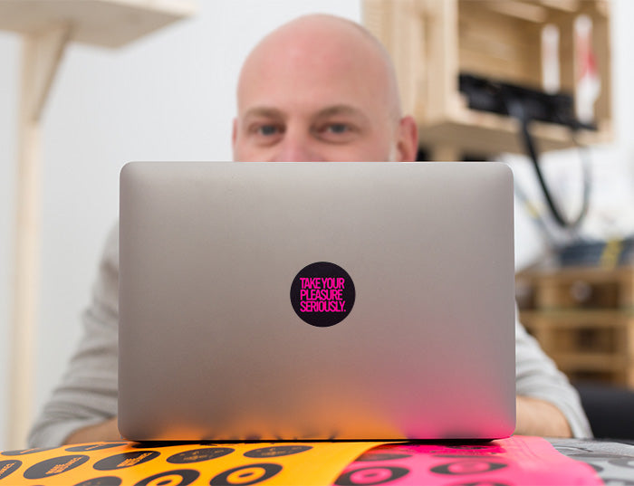 tabtag artis partisan behind a macbook with a neon decal on it