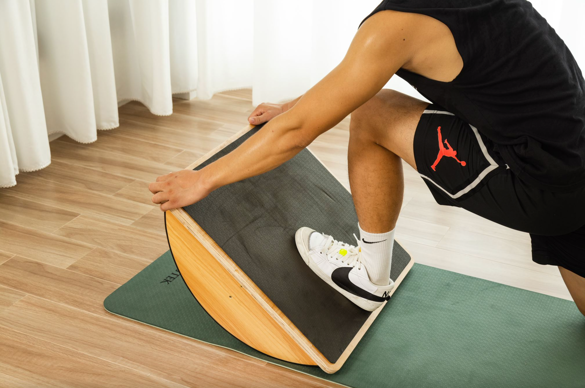 a man stretching calf using a balance board