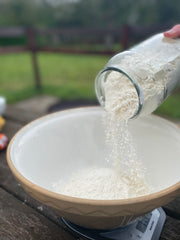 adding flour into a large mixing bowl