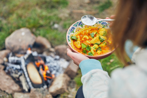 easting cauliflower curry made on the firepit