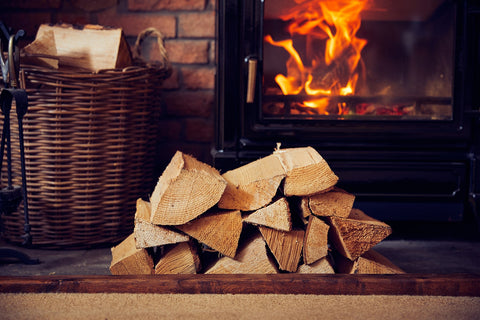 kiln dried logs in front of lit woodburning stove