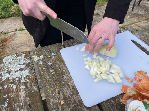 Chopping onions for a casserole cooking over wood