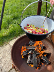cooking with a kotlcih over a firepit