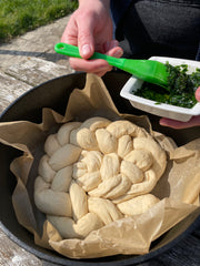 speading wild garlic pesto on bread dough