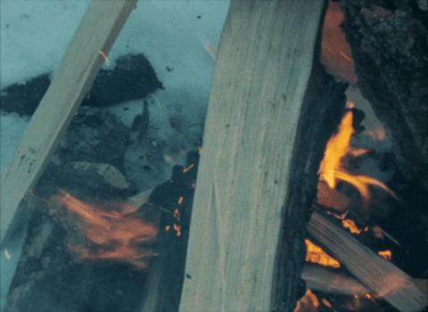 Man wearing beanie blowing fire in snowy climate