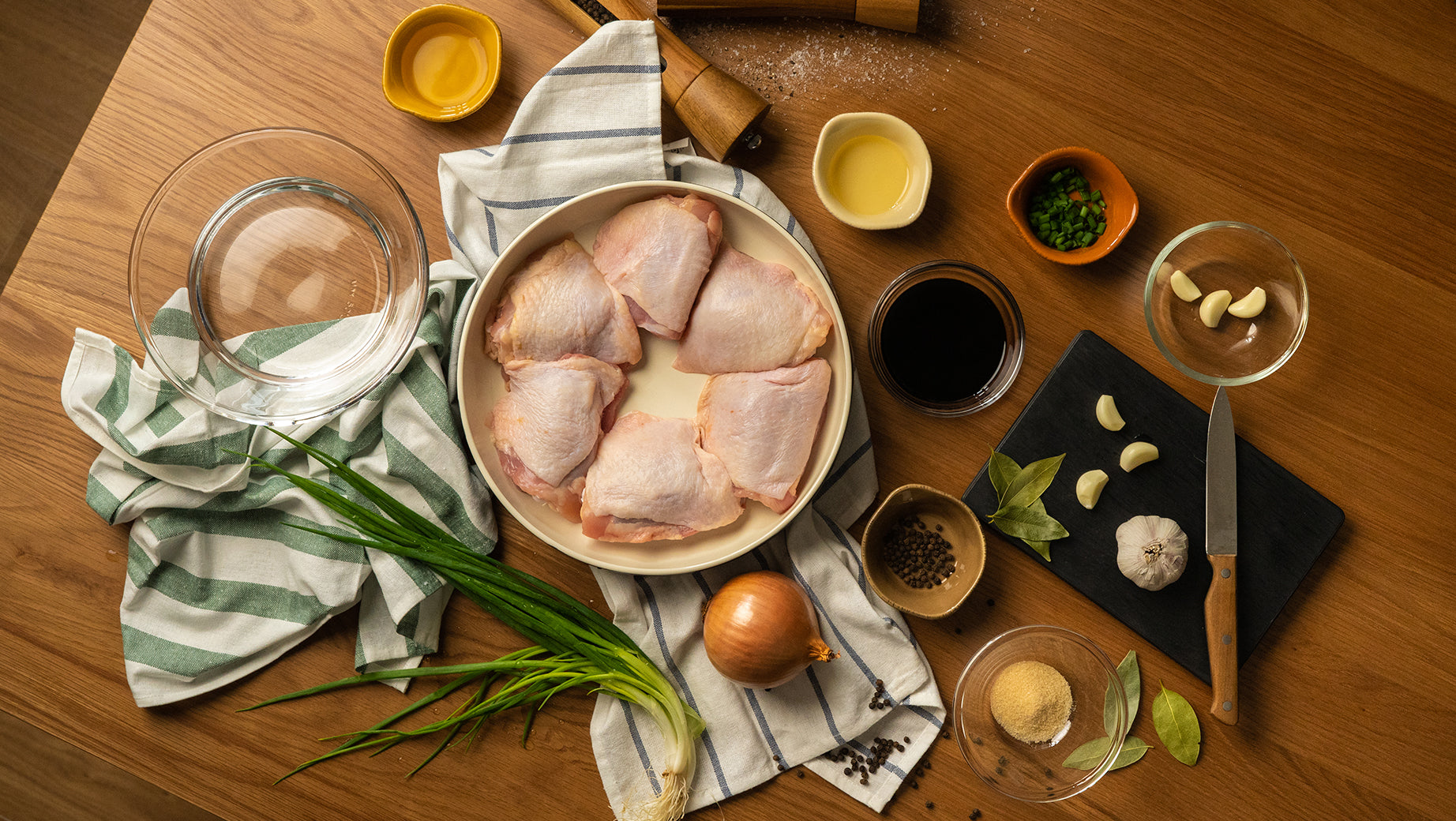 All ingredients for making Saucy Adobo Chicken arranged on a wooden table