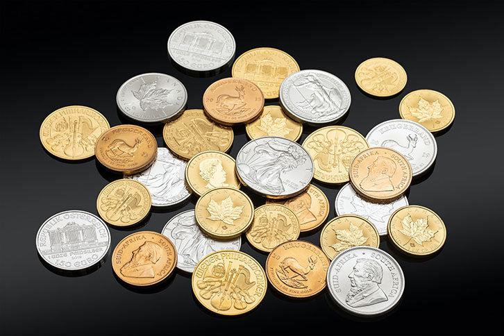 Pile of gold and silver bullion coins including, Royal Canadian Mint, U.S. Mint, Australian Mint of Perth, Münze Österreich and Krugerrand