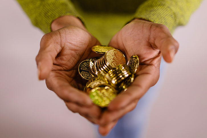 A pile of gold coins in someone’s hands