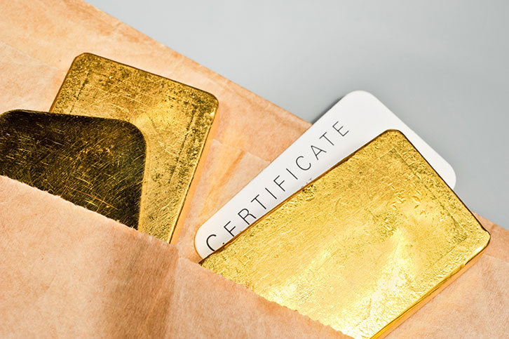 Several unmarked gold bars with a card saying certificate