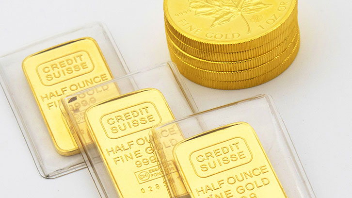 Three Credit Suisse half ounce gold bars and a stack of Canadian Gold Maple Leaf coins