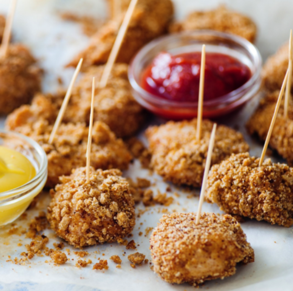 Chicken bites baked and covered in crumbled pretzels with toothpicks for easy snacking