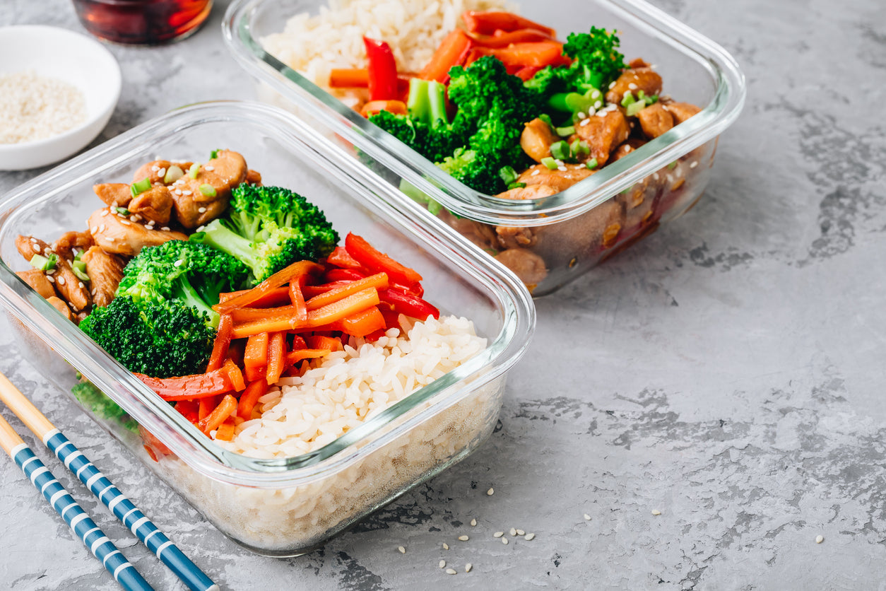 Tupperware with chicken, broccoli, rice, and peppers. 