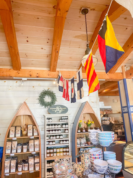 Shelves at a gift shop with nautical flags hanging above