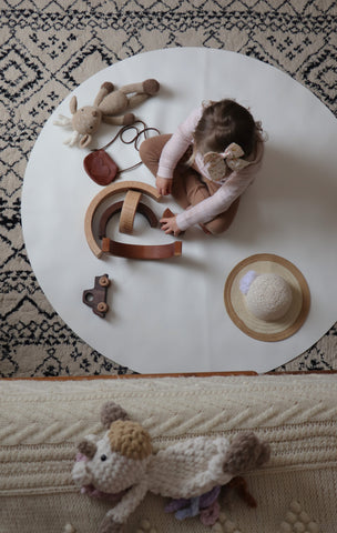 Girl using open ended toys on play mat