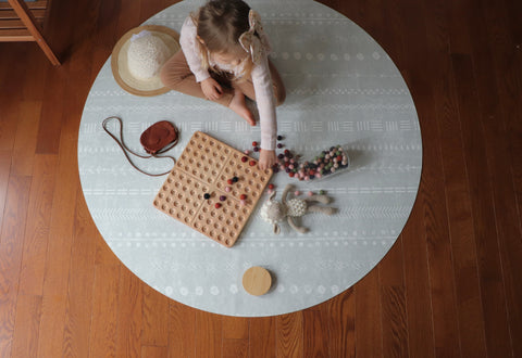 Girl using open ended toys on play mat