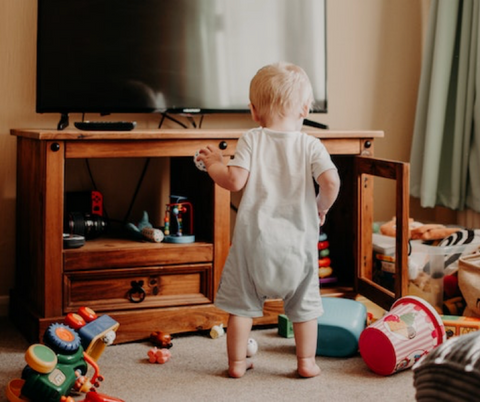 A toddler exploring an unlocked cabinet.