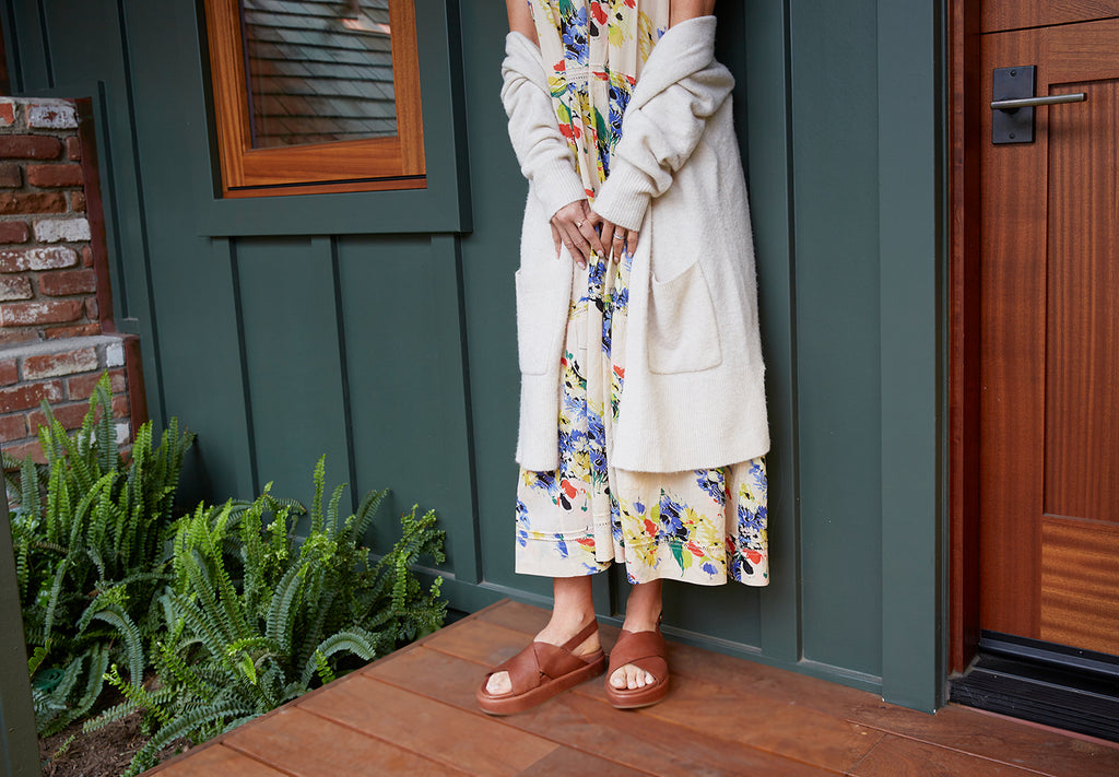 Woman wearing Gull leather sandals in cognac with floral dress and long cardigan.