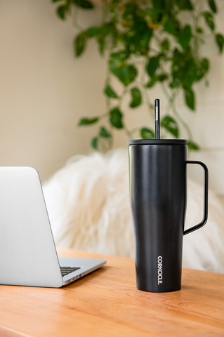 Corkcicle Insulated Water Bottle with Handle next to Computer