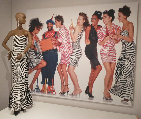 Wall size image of Patrick Kelly with his models wearing zebra print outfits. Also a mannequin  with a kelly zebra dress in front