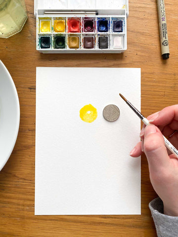 Paint a small circle of yellow paint about the size of a 10p piece