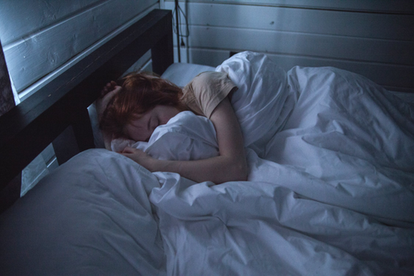 woman sleeping under blanket