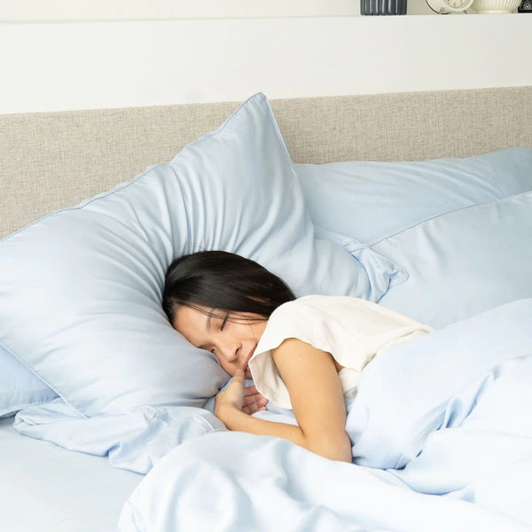 Woman sleeping on Weavve’s Signature TENCEL™ Lyocell Sheets in Sky Blue