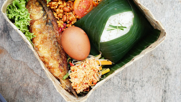 Fish, egg, rice, and sides served on a basket