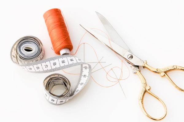 Measuring tape, thread, and scissors