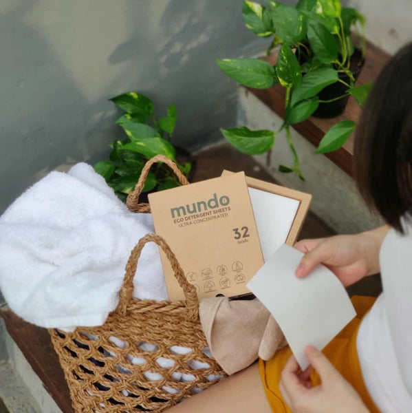 Woman about to wash her bed sheets with Mundo Eco Laundry Detergent Sheets