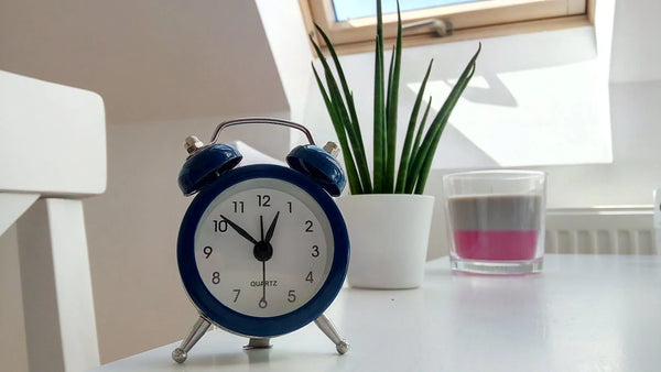 Blue alarm clock on a white table