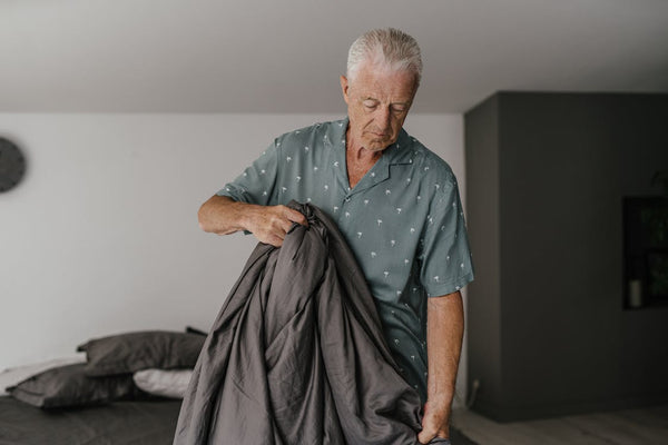 Elderly man fixing a duvet