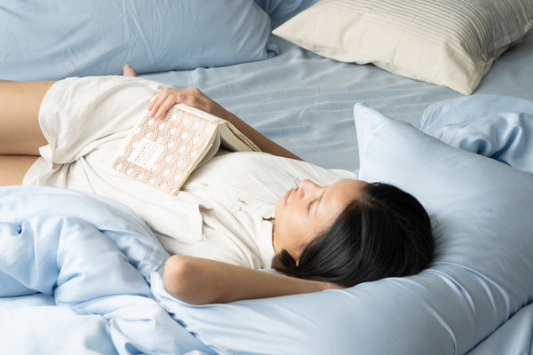 Girl lying on blue bed sheets