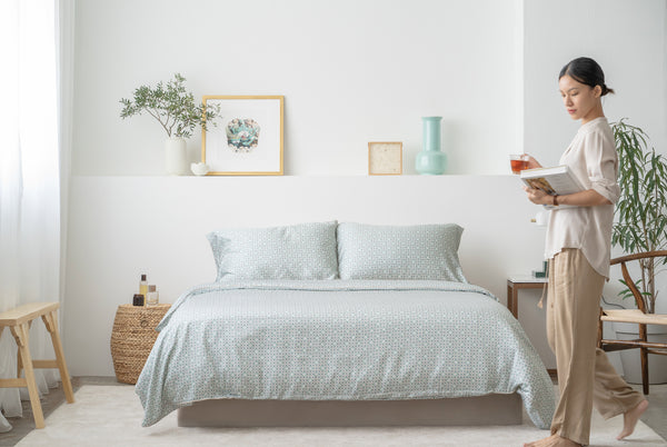 Girl walking around bedroom with patterned sheets