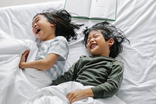 Kids giggling in bed with white down duvet