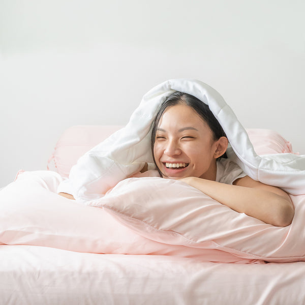 Girl on bed with duvet and TENCEL™ pillow case
