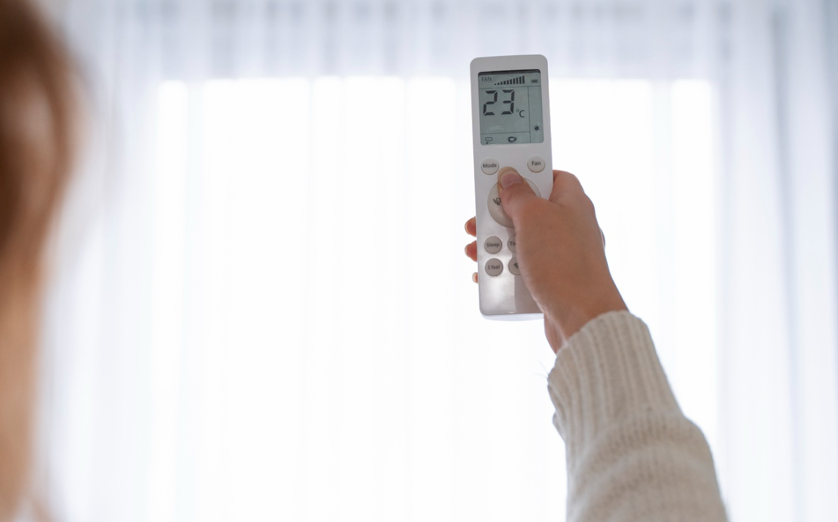 Woman holding remote to start the heater