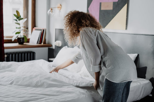 Woman in gray long sleeve shirt and blue denim jeans fixing alternative down duvet