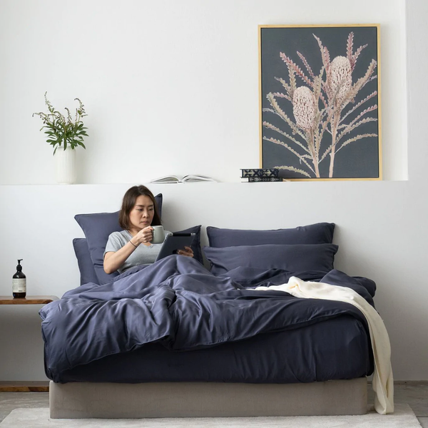 Woman sitting on bed while reading sleep myths