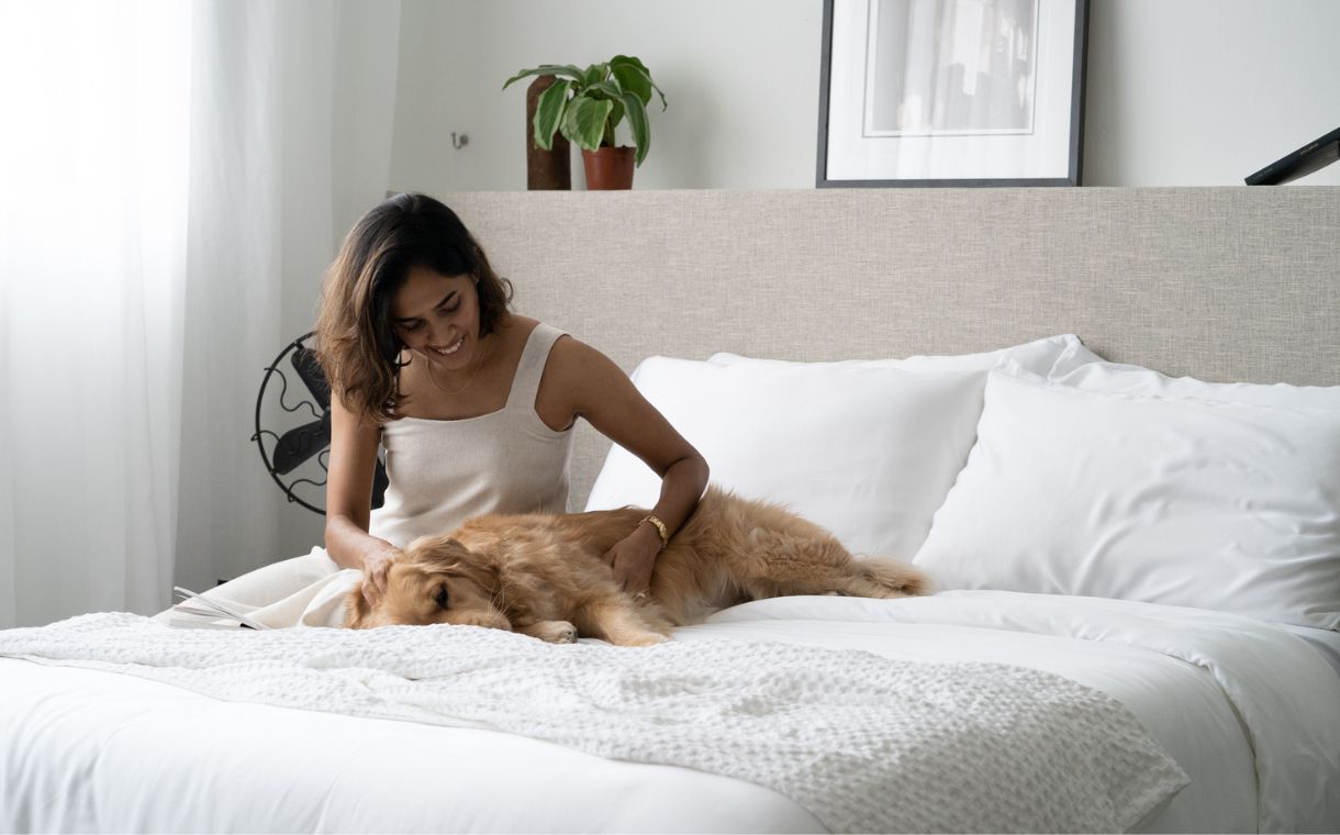 girl and dog playing on bed with Weavve Home white sheets