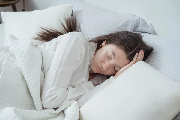 girl sleeping on white bed with white blanket