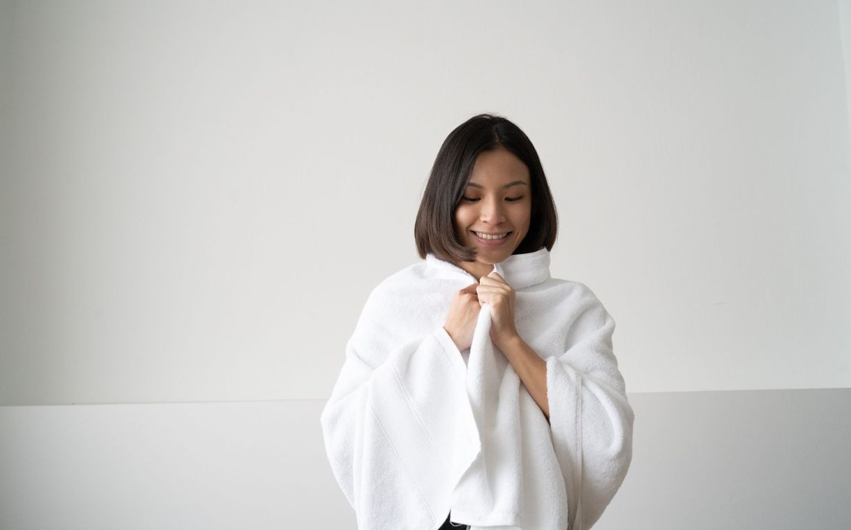 girl smiling while holding silver infused towel