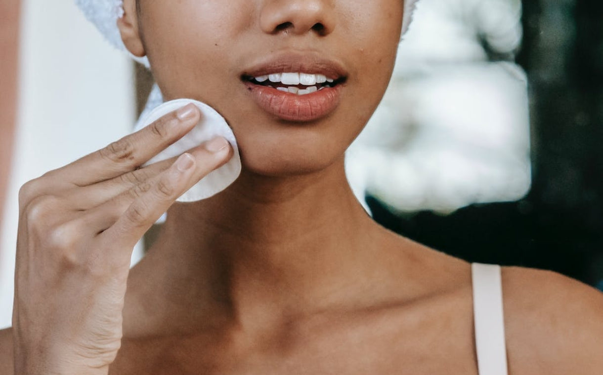 girl wiping her face with cotton