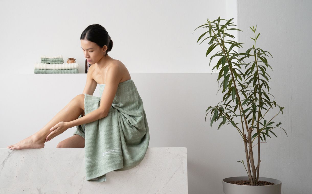 girl wrapped in Weavve Home's green bamboo towel