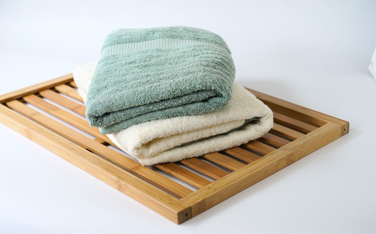 https://cdn.shopify.com/s/files/1/0106/0755/8722/files/green_folded_towel_on_top_of_a_white_folded_towel_2.jpg?v=1689837242